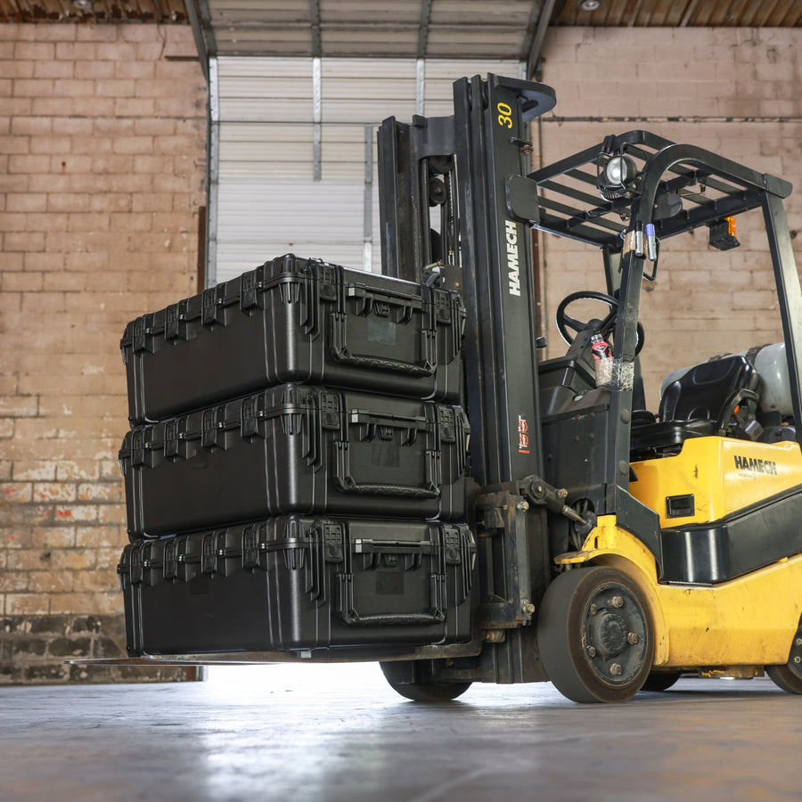 Forklift carrying three stacked black Condition 1 #2308 wheeled cases